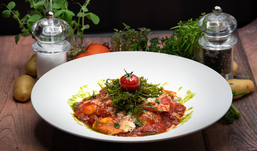 Ravioli mit Ziegenkäse und Pinienkernen
in Kirschtomatensugo und Hand gehobeltem Parmesan